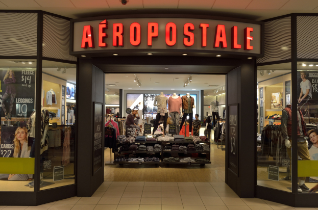 Aeropostale-Laden im Einkaufszentrum mit Kleiderstangen, Schaufensterpuppen in Kleidern, beleuchteten Schildern, Glaswänden und Leuchten, mit einer Ankündigung zur Schließung im Juni.