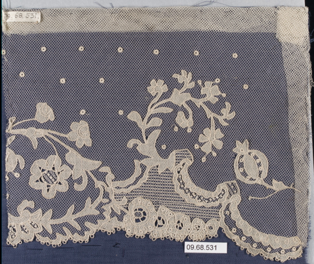 White lace with intricate floral design laid on a blue surface, featuring detailed patterns in various shapes and colors.