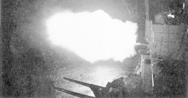 Ein Schwarz-Weiß-Foto einer großen Explosion in einem dunklen Raum, mit Rauch, der herausquillt, einer Stange und einer Wand auf der rechten Seite und Text unten.