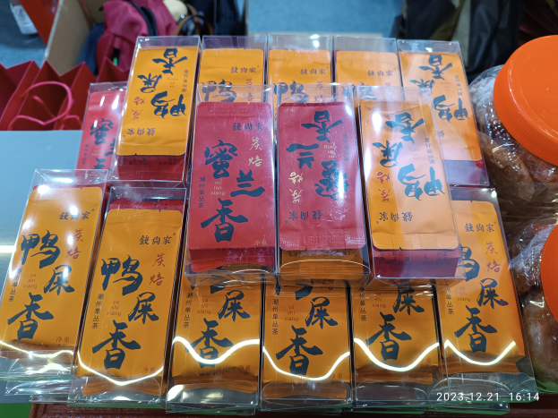 Ein Tisch voller verschiedener Arten von Lebensmitteln, darunter Verpackungen, Schachteln und Taschen, mit einer Person im Hintergrund während eines chinesischen Neujahrsfests.