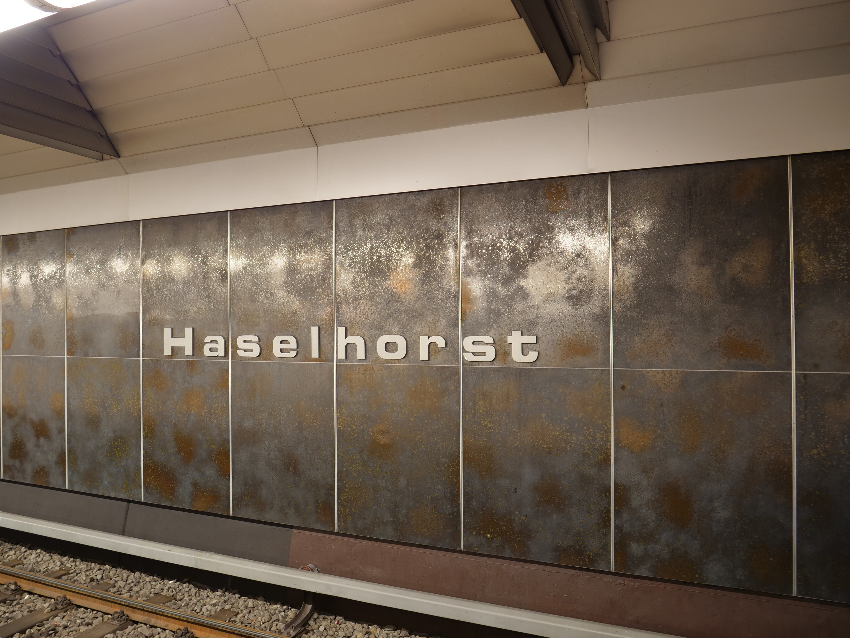 A train station sign reading "Haselhorst" illuminated on a wall in Berlin, Germany.