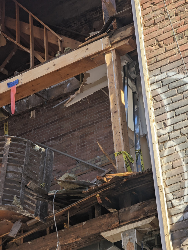 Teilweise abgerissenes Gebäude mit verstreuten Trömmern, zerbrochene Fenster und Türen nach Abriss.