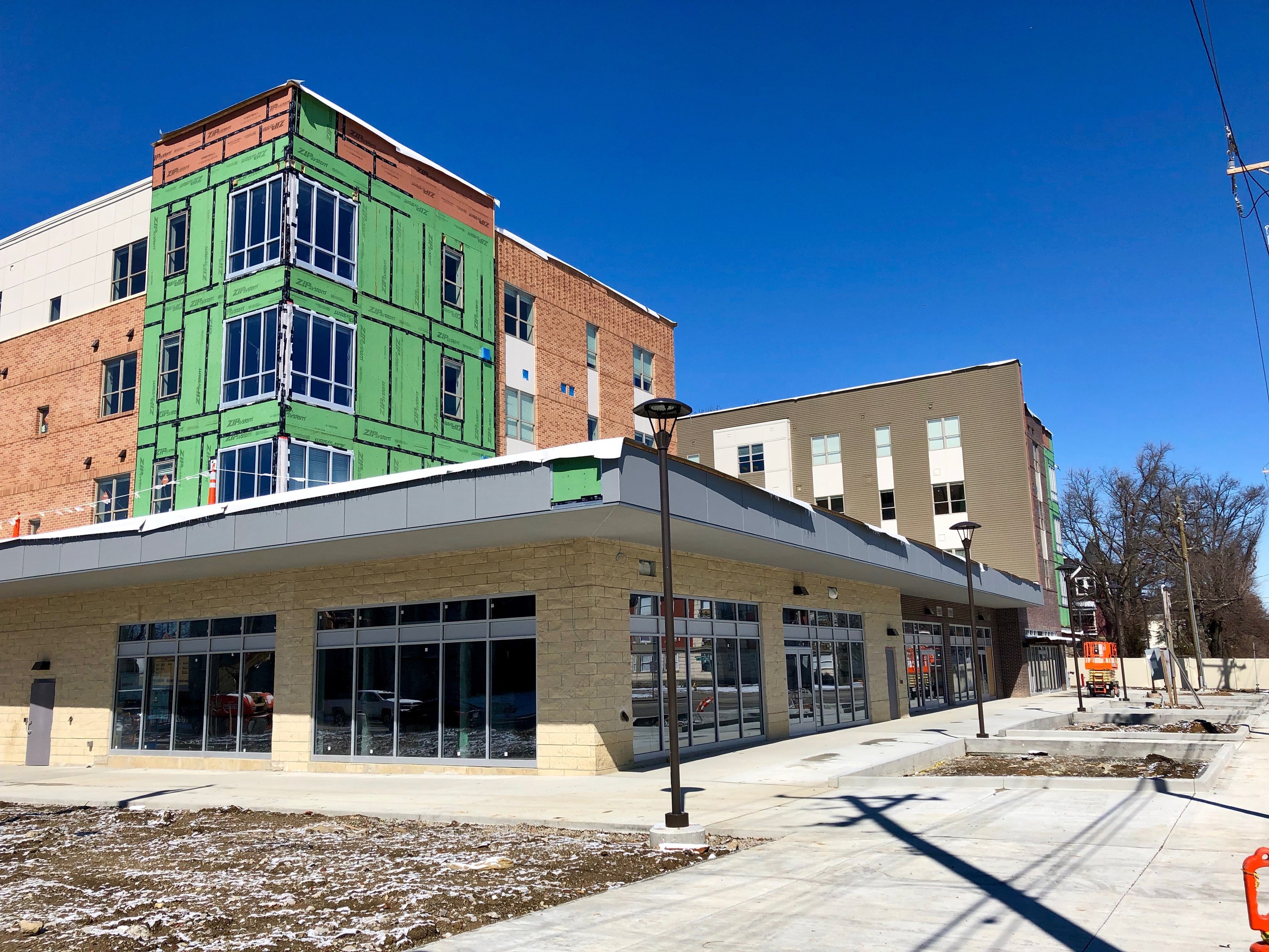 Large multi-story university building with numerous windows, surrounded by street infrastructure, vehicles, trees, and a cloudy sky, part of the University of Wisconsin-Madison campus.