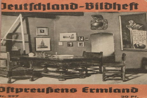 Old book titled "Deutschland-Bildheft - Offpreußens Ermland" published in 1927, featuring a cover illustration of a room with chairs, a table, objects on the table, photo frames on the wall, and a ladder.