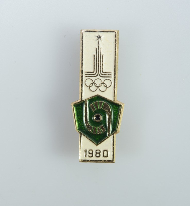 Eine weiße Oberfläche mit einem Abzeichen, das das Logo der Olympischen Spiele 1980 in Moskau zeigt, einschließlich Text und Zahlen.