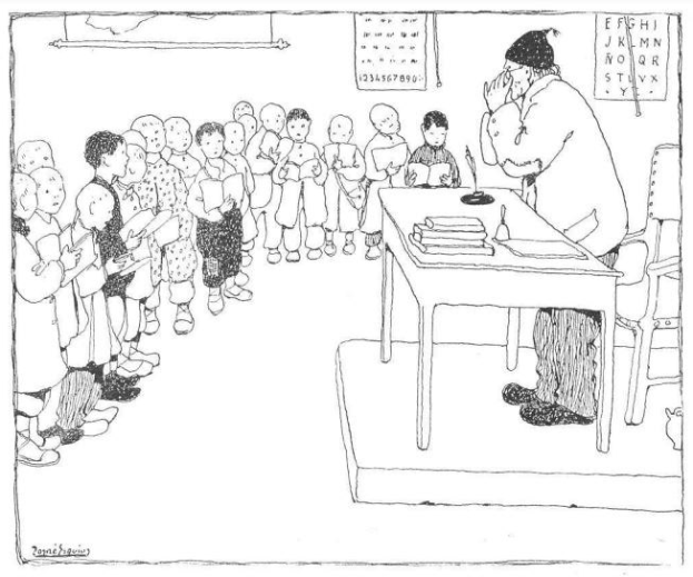 Ein Mann sitzt an einem Schreibtisch mit Büchern und Gegenständen vor einer Gruppe von Kindern, mit Papieren an der Wand hinter ihm, trägt Schuhe.