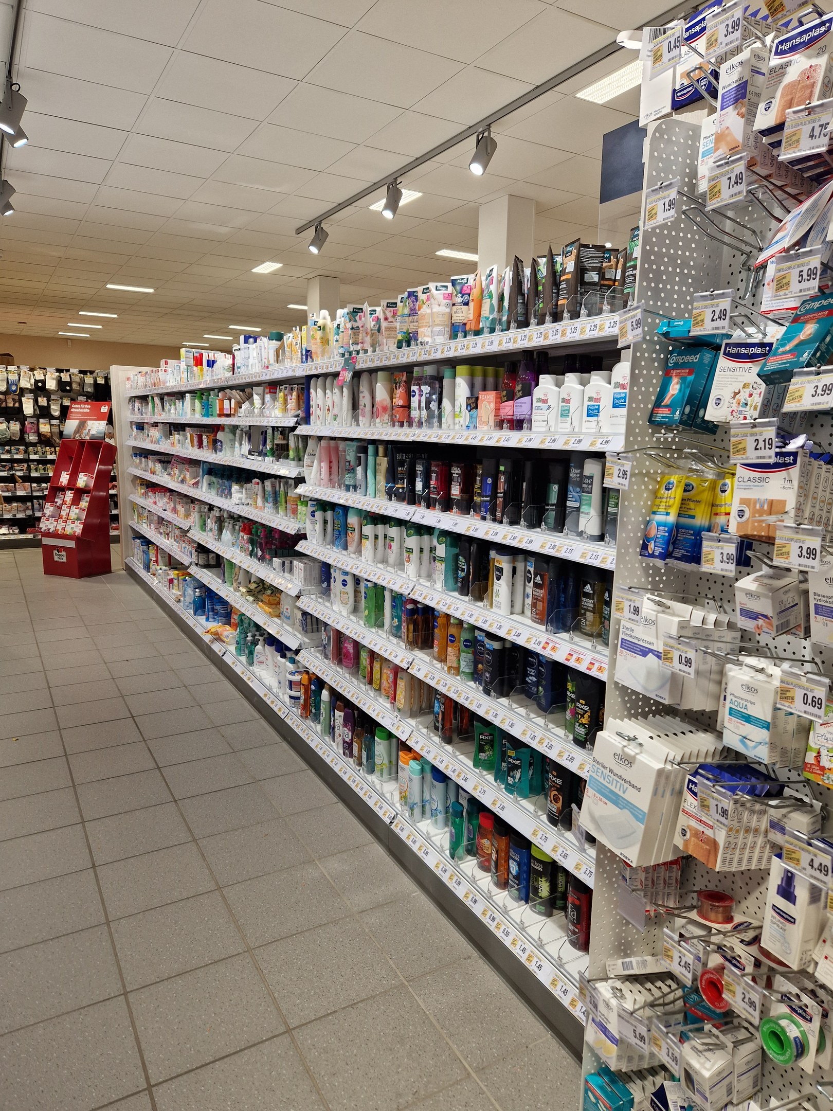 Apothekengang mit verschiedenen Medikamenten in Regalen angeordnet.