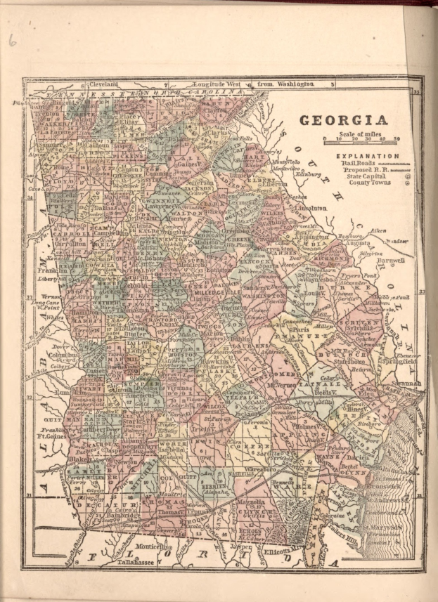 A worn book featuring a detailed map of Georgia, including counties and cities, with accompanying text.