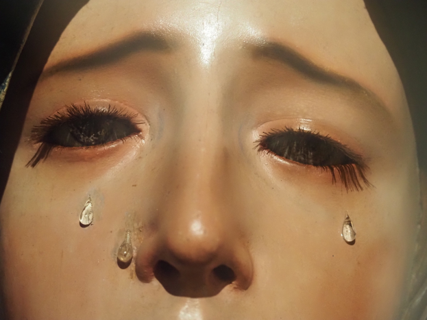 Eine Frau mit Tränen auf den Wangen, ihr Gesichtsausdruck zeigt Trauer und Verzweiflung.