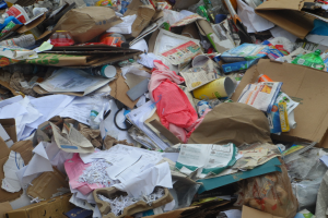 Ein Haufen Kartons mit Papieren, Flaschen, Abdeckungen und anderen Gegenständen.