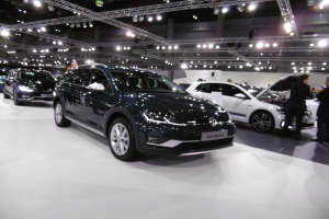 Ein Volkswagen Golf Alltrack auf der IAA in Frankfurt umgeben von Menschen und beleuchtet von Deckenlampen.