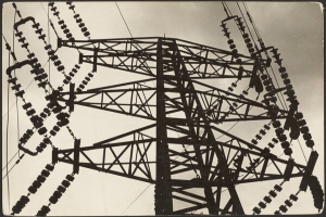 Ein Schwarz-Weiß-Foto einer Hochspannungsleitung mit einem Mast und Drähten im Vordergrund und einem Himmel im Hintergrund, mit Text am unteren Rand des Bildes.