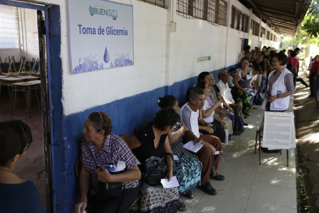 Menschen sitzen auf Bänken vor einem Gebäude und warten in der Schlange, um bei einer Wahlurne in Guadalajara, Mexiko, ihre Stimmen abzugeben.