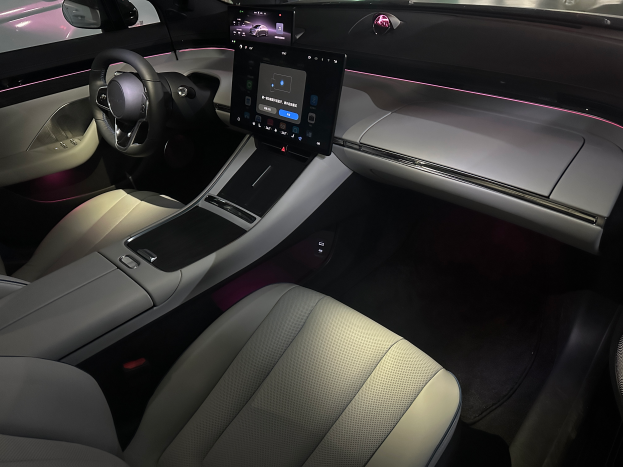 Das Innere eines Jaguar I-Pace Concept-Autos mit schwarzem Lederdesign, großem Touchscreen-Display, ledernem Lenkrad mit Silberakzenten und einer Mittelkonsole mit Becherhalter und Gangschaltung.