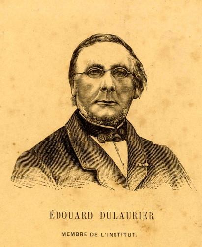 Black and white portrait of Edouard Dulaurier in a suit and tie, wearing glasses with a serious expression, with French text at the bottom.