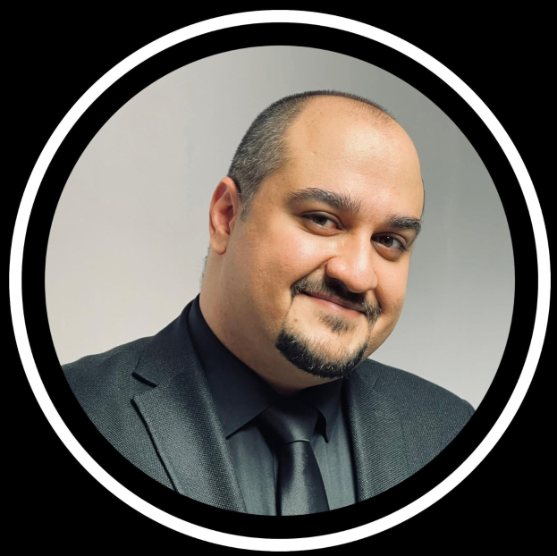 Ein Mann in Anzug und Krawatte mit einem Lächeln vor einem schwarzen Hintergrund, betitelt als Anwalt in New York City.