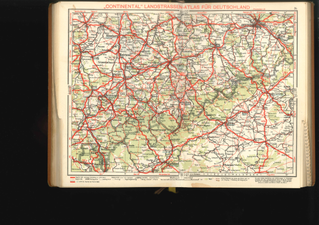 Offenes Buch mit einem detaillierten Plan von Deutschlands Straßen und Autobahnen auf einem schwarzen Hintergrund.