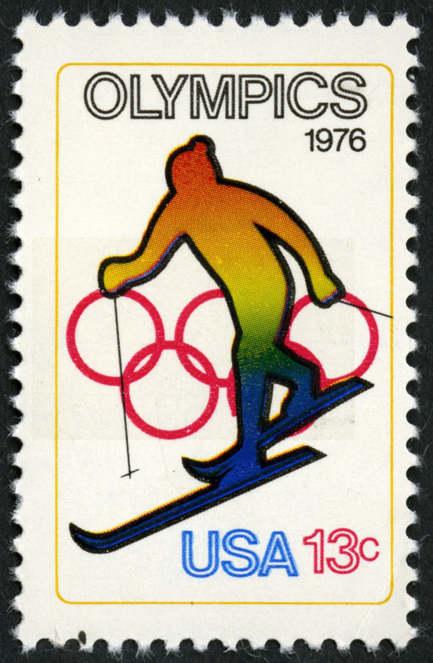 Schwarze Briefmarke mit Olympischem Logo, das einen Skifahrer zeigt, und Text.