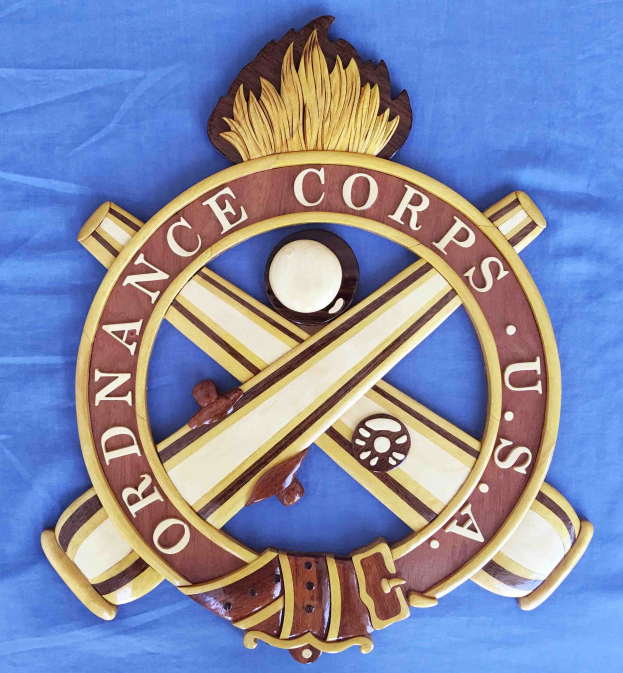 Holzschild mit "Ordnance Corps" in schwarzer Schrift, auf blauem Tuch montiert, mit weißem Stern auf navy-Blue-Hintergrund mit goldener Umrandung und detailreichen Verzierungen.