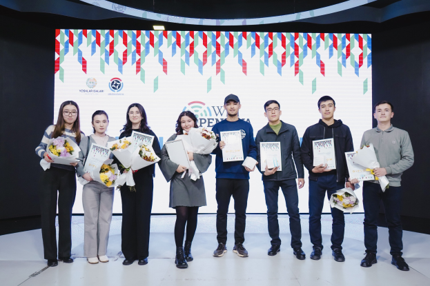Group of people on a stage holding bouquets and certificates, with a screen displaying "Yogyakarta Penang International School" in the background.
