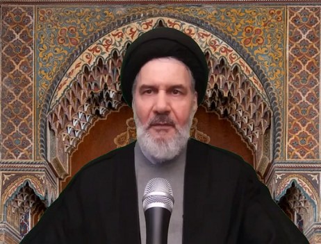 Ayatollah Ali Khamenei, der Oberste Führer von Iran, trägt eine schwarze Robe und eine Turbans und spricht an einem Podium mit einem Mikrofon vor einer Wand mit kunstvollen Designs.