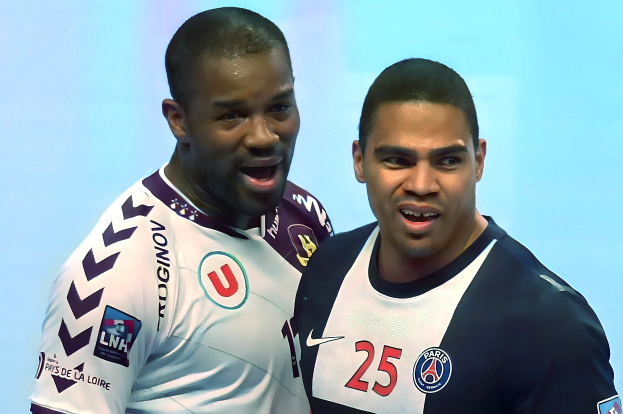 Zwei Männer in weiß-blauen T-Shirts auf einem Fussballfeld mit einem hellblauen Hintergrund, die einen Sieg feiern.